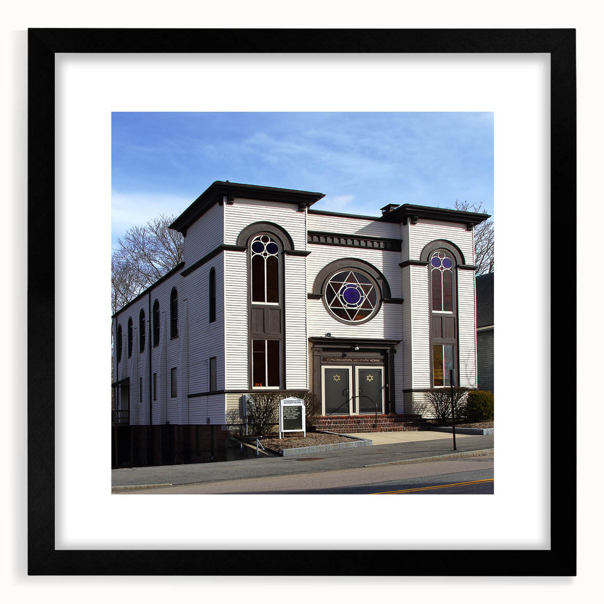 Abstract, colorful art print of a synagogue, featuring a textured style in vibrant hues, framed in black.