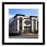 Abstract, colorful art print of a synagogue, featuring a textured style in vibrant hues, framed in black.
