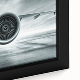 Close-up of a black framed canvas featuring a colorful, textured depiction of an airplane.