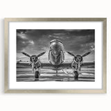 Textured abstract art print of an airplane in muted gray tones on a framed silver mat, ideal for modern bedroom decor.