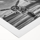 Art deco poster of a vintage airplane in muted silver and blue tones on rolled canvas.