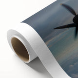 Art deco poster of an airplane in flight, featuring bold black and gold colors on a rolled canvas.