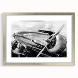 Textured art print of abstract airplanes in muted gray and blue tones on a silver-framed mat, ideal for bedroom wall decor.