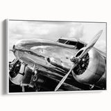 Framed canvas of a vintage airplane in flight against a stark black background, ideal for bedroom wall art.