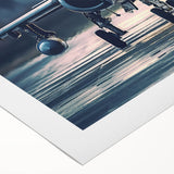 Art deco poster of an airplane in flight, featuring bold geometric patterns and metallic colors on a rolled canvas.