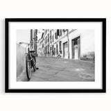 Abstract art print of a colorful, textured bicycle on a large canvas, framed in black, suitable for living room decor.