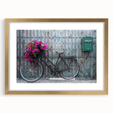 Abstract art print of a stylized bicycle in gold and black tones, framed with a mat.