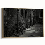 Vintage poster art of a black bicycle on a gold-framed canvas, ideal for bedroom wall decor.