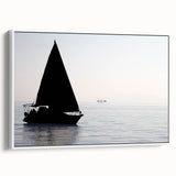 Framed canvas depicting a vintage-style sailboat on a muted black and gray sea, ideal for bedroom wall art.