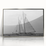 Art deco poster of a sailboat on acrylic, framed in silver, featuring cool blue and white tones.
