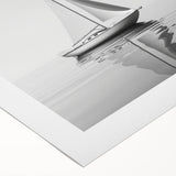 Art deco poster of a sailboat on a rolled canvas, featuring pastel blue and white tones, ideal for dining room wall art.