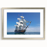 Abstract art print of a stylized ship in silver and blue tones on a framed canvas, suitable for bedroom or dining room decor.