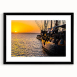 Abstract art print featuring a colorful, textured depiction of ships, in a black frame with mat, ideal for living room decor.