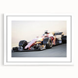 Abstract art print of race cars in motion, using dynamic blue and red strokes on a white framed canvas.