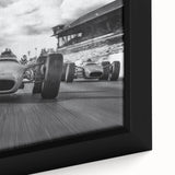 Framed canvas depicting a close-up of race cars in motion, with a black background and vibrant, textured color accents.