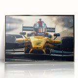 Mid-century modernist art featuring race cars in vibrant colors on a silver-framed acrylic print.