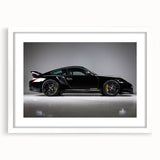 Abstract art print of a sports car in vibrant red and black hues on a white framed canvas.