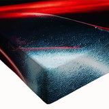 Black and white photo of sports cars in motion on a track, printed on large stretched canvas.