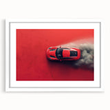 Abstract art print of sport cars in vibrant red and blue tones on a framed white mat.