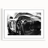 Abstract art print of a stylized sports car in vibrant red and black, framed in white.
