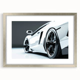 Textured art print of abstract sports car in silver and black hues, framed with a silver mat, suitable for bedroom decor.