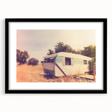 Abstract art print featuring a colorful, textured caravan in muted earth tones on a large framed canvas.