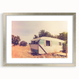 Abstract art print of a caravan in muted earth tones, framed in silver, ideal for dining room decor.