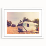 Extra large abstract art print featuring a textured depiction of a caravan in muted earth tones, framed in white.
