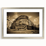 Textured abstract art print of service vehicles in muted gray tones on a silver-framed mat, suitable for bedroom decor.