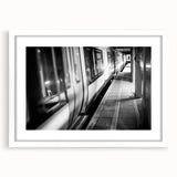 Abstract art print of a stylized train in muted gray and blue tones, framed with a white mat.