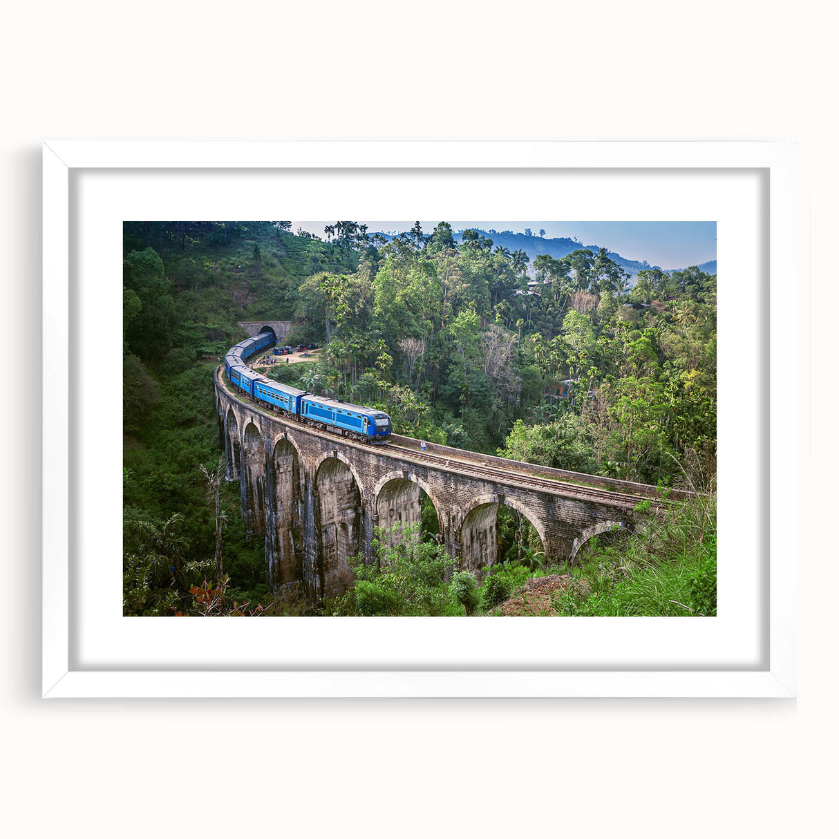 Abstract art print of a stylized train in shades of gray and blue on a white framed canvas.