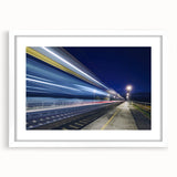 Abstract art print of a stylized train in muted gray and blue tones on a white framed poster, suitable for dining room decor.