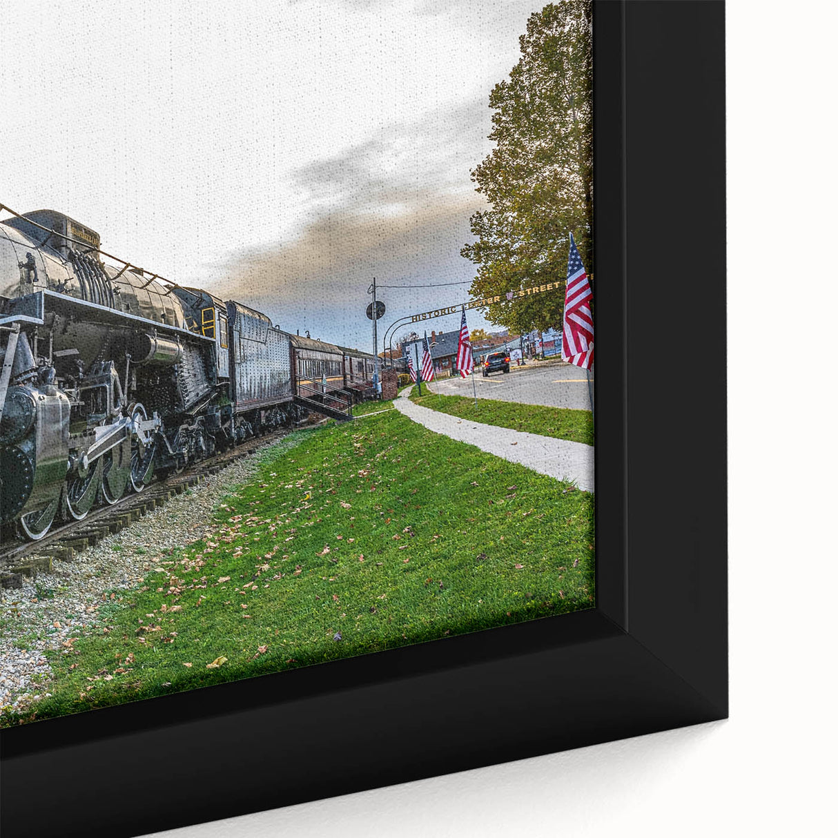Framed canvas featuring a close-up of a black train with colorful, textured details.