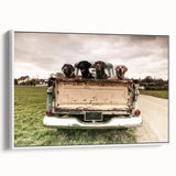 Vintage poster art of colorful trucks on a black background, printed on a large framed canvas.