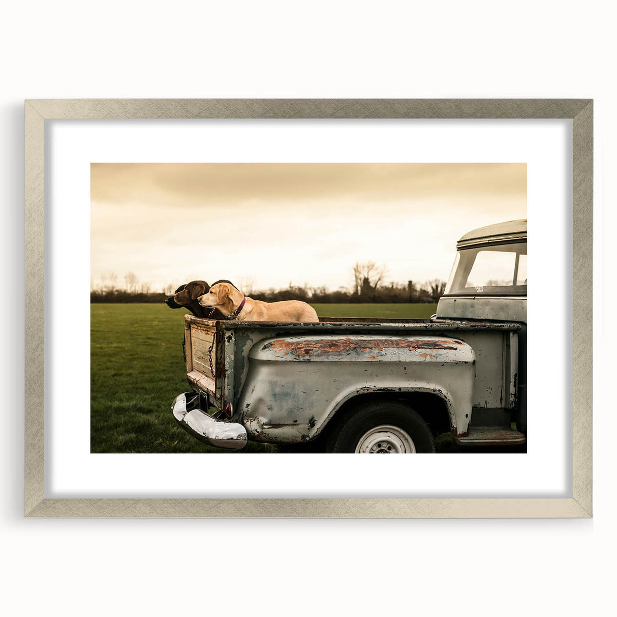 Textured art print of abstract trucks in muted gray and blue tones, framed with a silver mat, suitable for bedroom decor.