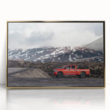 Mid-century modernist art featuring a series of colorful trucks on a gold-framed acrylic print.