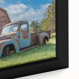 Close-up of a black framed canvas featuring a colorful, textured depiction of trucks.