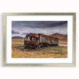 Abstract art print featuring textured trucks in neutral tones on a framed silver mat, suitable for bedroom decor.